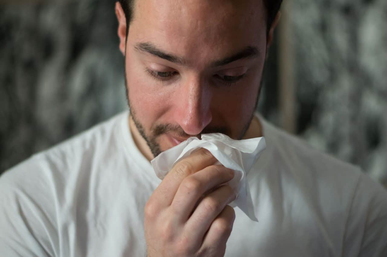 Man with tissue to nose