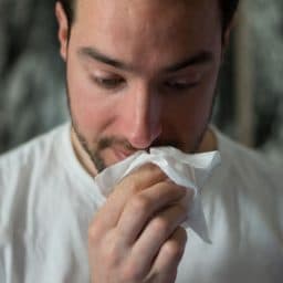 Man with tissue to nose