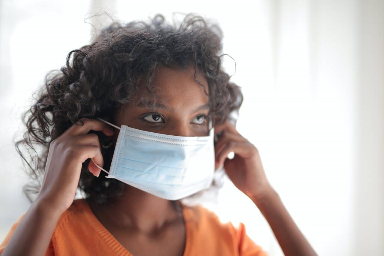 woman putting on basic face mask