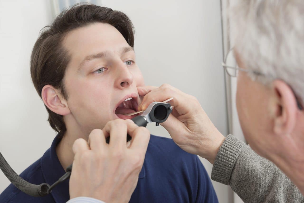 Man getting his throat examined by a doctor