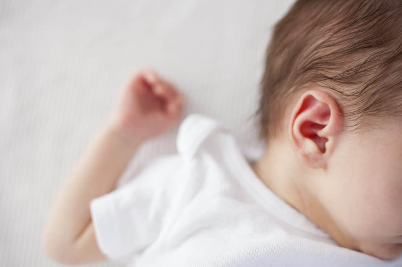 close up of a baby laying down and their ear exposed