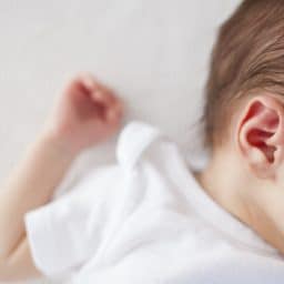 close up of a baby laying down and their ear exposed