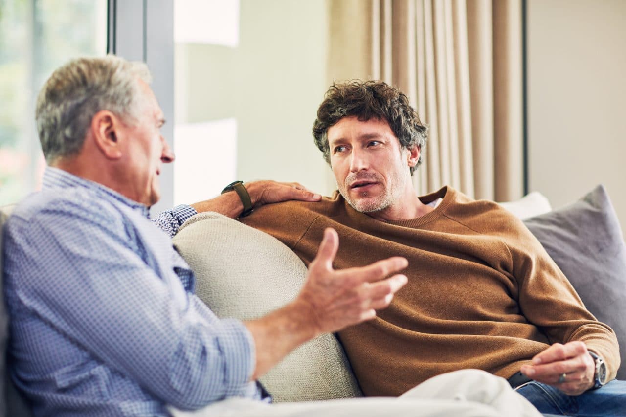 Shot of a mature man and his elderly father sitting on the sofa at home and chatting