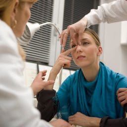 Woman being examined by doctors for Rhinoplasty surgery
