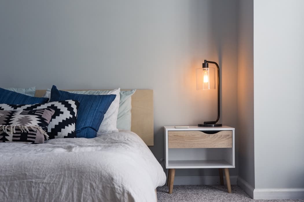 Bed and nightstand with lamp.