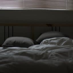 A bed and pillows in a dark room.