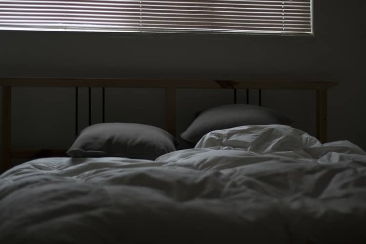 A bed and pillows in a dark room.