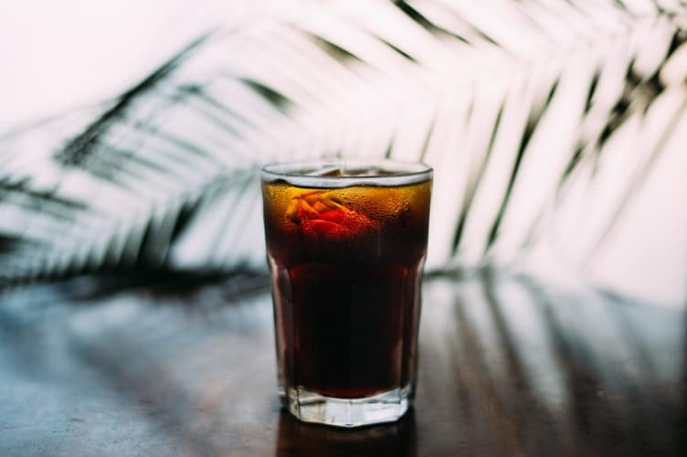 An iced dark beverage in a clear glass.