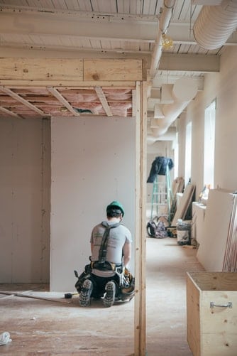 Construction worker on the job inside of an incomplete building.