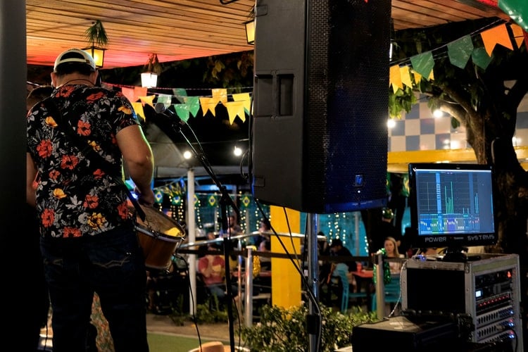 A musician playing a show next to a listening monitor.