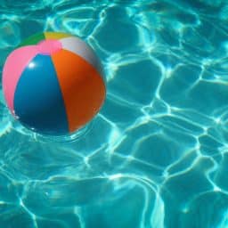 A beach ball floating in a swimming pool.