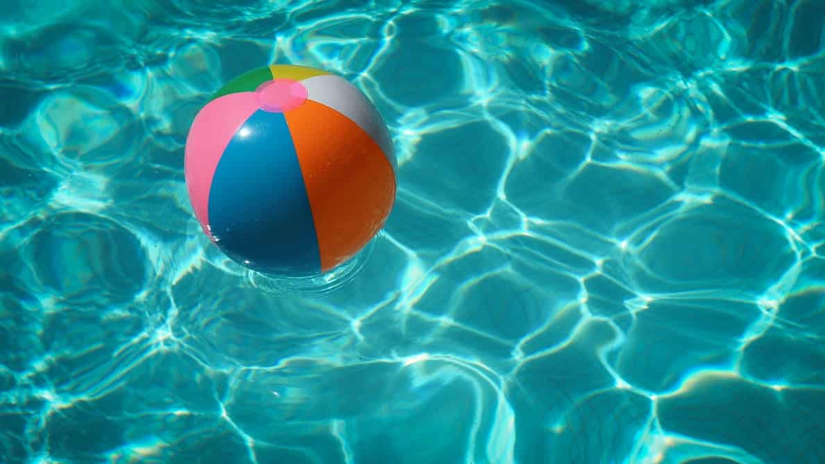 A beach ball floating in a swimming pool.