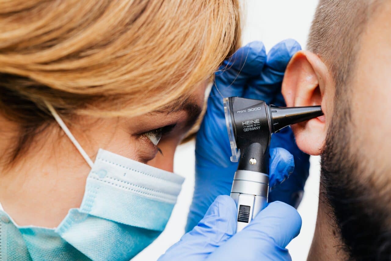 Doctor examining the ears of a man with sudden hearing loss.