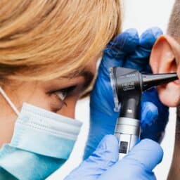 Doctor examining the ears of a man with sudden hearing loss.