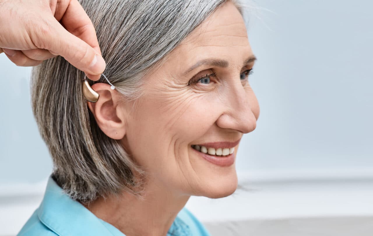 Hearing aid placed behind woman's ear