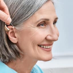 Hearing aid placed behind woman's ear