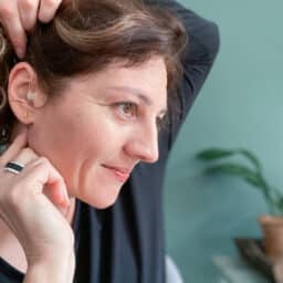 Woman touches hearing aid