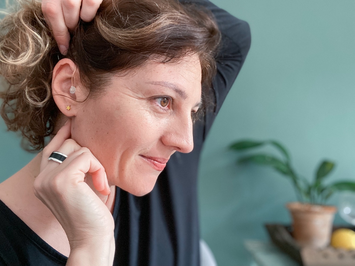 Woman touches hearing aid