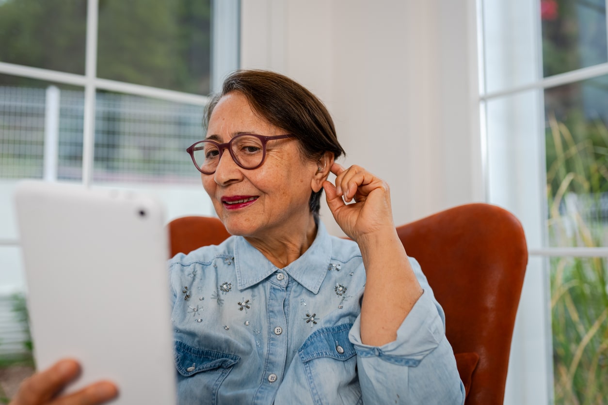 Woman touches ear while talking on phone