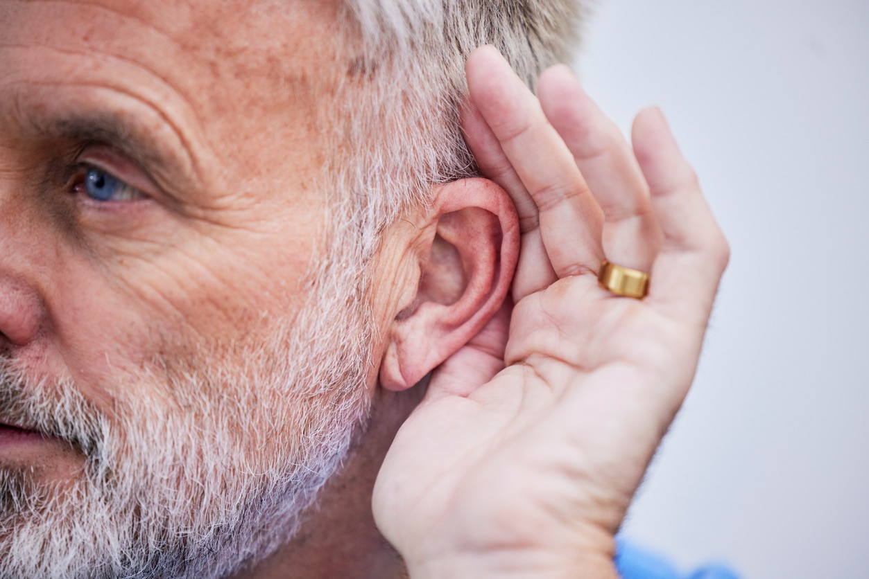 Man holds hand to ear to hear better