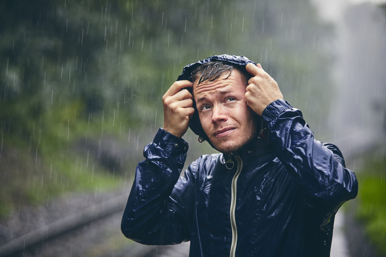 Man wearing a rain jacket in the pouring rain.