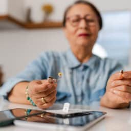 Senior woman holding her hearing aids.