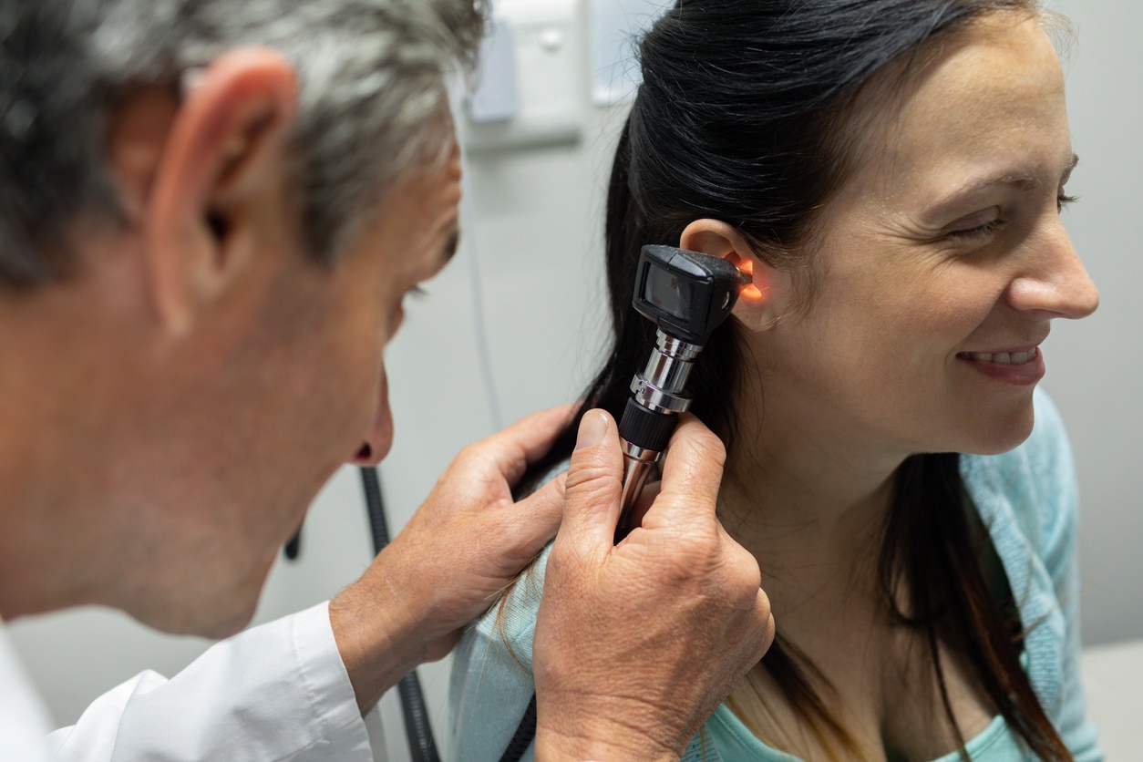 ENT checking a woman's ear for blockages.