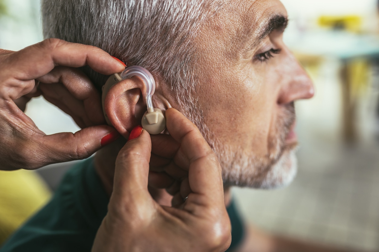 Senior man getting his new hearing aid.