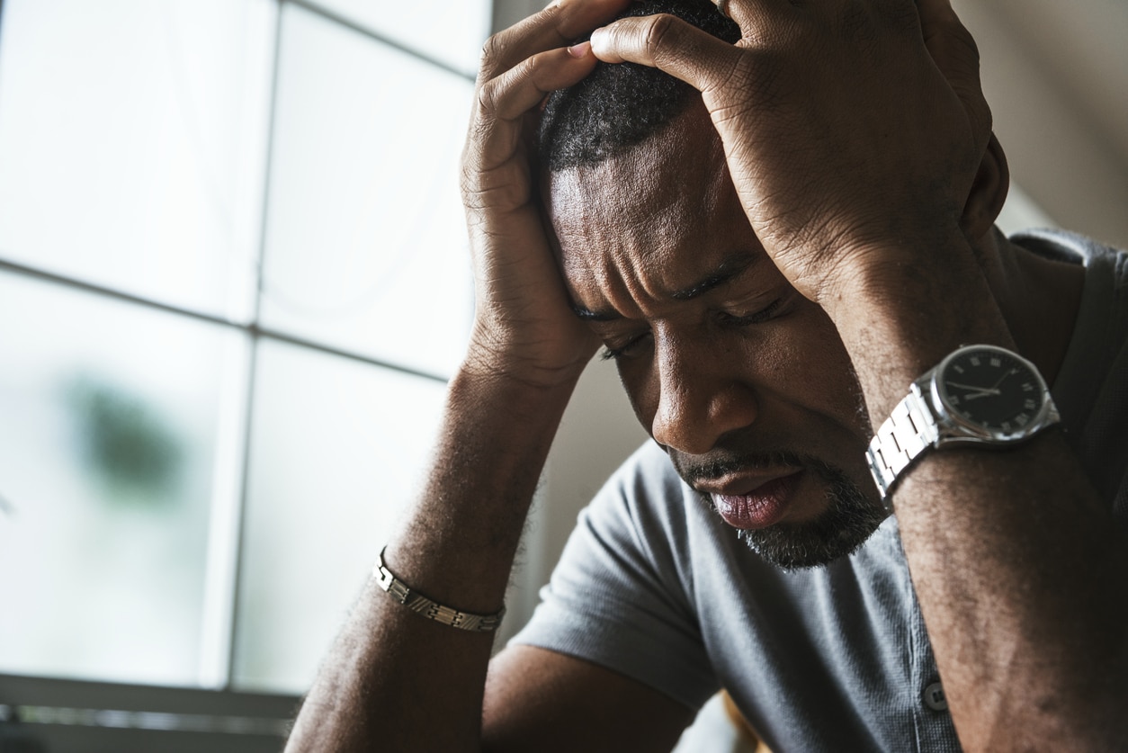 Frustrated man holding his head in his hands.