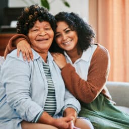 Daughter hugging her mom on the couch