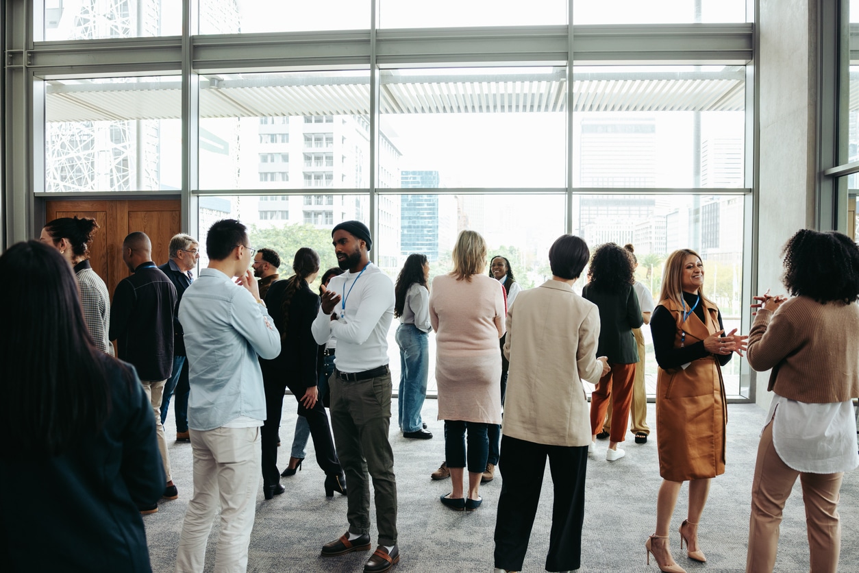 Small crowd of people standing in an office.